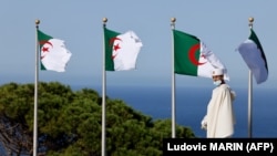 ARCHIVES - Un homme passe devant le drapeau national de l'Algérie à Alger, le 25 août 2022.