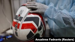 Seorang karyawan Shellios Technolabs, yang memproduksi helm sepeda motor yang dilengkapi dengan filter dan kipas di bagian belakang helm, sedang merakit helm di New Delhi, India, 23 Agustus. 2022. (Foto: REUTERS/Anushree Fadnavis)