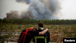 Firefighters react as they work to contain a fire in Saint-Magne, as wildfires continue to spread in the Gironde region of southwestern France, Aug. 11, 2022. 
