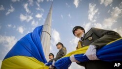 In this photo provided by the Ukrainian Presidential Press Office, honour guard soldiers prepare to rise the Ukrainian national flag during State Flag Day celebrations in Kyiv, Ukraine, Tuesday, Aug. 23, 2022.