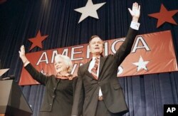 FILE - President-elect George H.W. Bush, right, and his wife Barbara Bush, wave to the crowd at a victory celebration rally, Nov. 8, 1988, Houston, Texas.