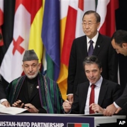 Afghan President Hamid Karzai and NATO Secretary General Anders Fogh Rasmussen sign a declaration between NATO and the Afghan government on enduring partnership, as UN General Secretary Ban ki-Moon, centre, looks on at the NATO summit in Lisbon (file phot