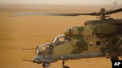 FILE - A Russian military helicopter flies over Deir el-Zour province, Syria, Sept. 15, 2017. A U.S.-backed force in Syria said a Russian airstrike killed one of its fighters and injured two others in the province.