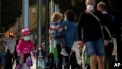 26일 스페인 바르셀로나에서 가족들이 산책하고 있다. 앞서 스페인 정부는 14세 이하 어린이들이 부모와 동행할 경우 1시간 외출할 수 있도록 봉쇄령을 완화했다.