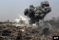 FILE - Smoke billows after an airstrike by the U.S.-led international coalition forces targeting Islamic State in Mosul, July 9, 2017.