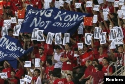 Hong Kong fans hold banners and character signs that read "Hong Kong is not China," during the Chinese national anthem at the 2018 World Cup qualifying match between Hong Kong and China, in Hong Kong, Nov. 17, 2015.