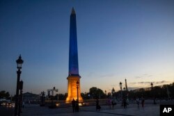 The obelisk of the Place de la Concorde is illuminated with the colors of Ukraine to mark six months into the war in Ukraine following its February 24, 2022, invasion by Russia, Aug. 24, 2022 in Paris.
