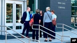 U.S. Department of Justice attorney Brian Netter, left, talks with others outside the federal courthouse in Boise, Idaho, Aug. 22, 2022. On Aug. 24, a judge in Boise blocked Idaho from enforcing an abortion ban when women with pregnancy complications require emergency care.