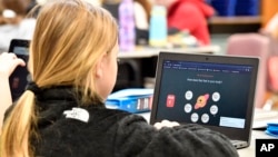 A student at Lakewood Elementary School in Cecilia, Ky., uses her laptop to participate in an emotional check-in at the start of the school day, Thursday, Aug. 11, 2022. (AP Photo/Timothy D. Easley)