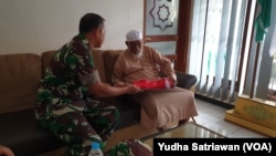 Abu Bakar Baasyir menerima bendera merah putih dari Komandan Korem Warastratama Surakarta, Selasa sore (16/8). Foto : VOA / Yudha Satriawan