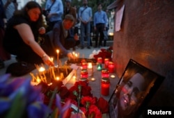 Flowers and candles are placed next to a portrait of media commentator Darya Dugina, who was killed in a car bomb attack, in Moscow, Russia August 22, 2022. (REUTERS/Maxim Shemetov)