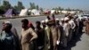 Displaced families line up to receive food after fleeing their flood-hit homes, in Charsadda, Pakistan, Aug. 29, 2022. International aid was reaching Pakistan on Monday, after widespread flooding driven by "monster monsoons" has claimed more than 1,000 lives since June.