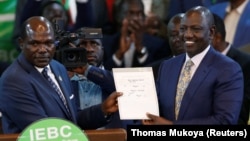 Le vice-président sortant du Kenya, William Ruto (à dr.), reçoit son certificat de victoire des mains du président de la commission électorale du Kenya à Nairobi, Kenya, le 15 août 2022.