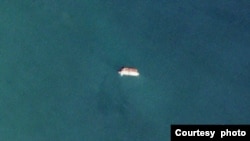Two vessels identified by TankerTrackers.com as Iranian state-owned Polaris 1 (smaller tanker) and Rhine Shipping DMCC-operated Babel (larger tanker) engage in a ship-to-ship-transfer in waters off Iraq's Al-Faw peninsula, March 17, 2020 (Planet Labs)