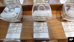 FILE - Samples of marijuana, in tamper-proof containers that are secured with cables, are displayed at Evergreen Cannabis, a marijuana retail shop, in Vancouver, British Columbia, Oct. 9, 2019.