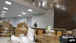 A journalist stands next to the boxes collected from the polling stations of the legislative elections, at the Palais de Justice in Dakar, Senegal on Aug. 4, 2022.