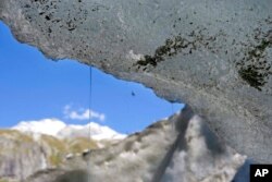 FILE - Water drops from the Ferpecle glacier in the Herens Valley, Canton of Valais, Switzerland, Aug. 23, 2006.