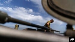 A Ukrainian serviceman stands on top of a tank while taking a break during training with his unit in the Donetsk region, eastern Ukraine, Monday, August 22, 2022
