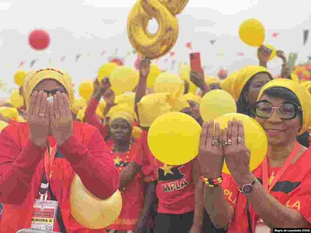 Apoiantes do MPLA, membros da Organização da Mulher Angolana (OMA) no comício de encerramento de campanha do partido, mostram os dedos aludindo ao número 8, número do MPLA no boletim de voto. Camama, Luanda. Angola 20, 2022