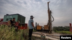 2022年8月27日，中国江西省九江市外，打井队队长高普察在打井，当地目前正在经历了一场严重干旱。