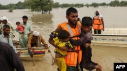 Des secouristes aident à évacuer les personnes touchées par les inondations de leurs maisons après les fortes pluies de mousson dans le district de Rajanpur, dans la province du Punjab, au Pakistan, le 27 août 2022.