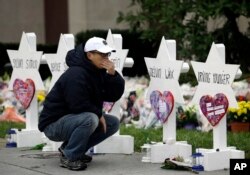 A person pauses in front of Stars of David with the names of those killed in a deadly shooting at the Tree of Life Synagogue, in Pittsburgh, Oct. 29, 2018.