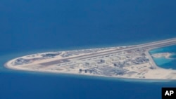 Chinese structures and an airstrip on the man-made Subi Reef at the Spratly group of islands in the South China Sea are seen from a Philippine Air Force C-130 transport plane of the Philippine Air Force, April 21, 2017.