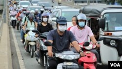 អ្នកបើកបរ​កំពុង​ធ្វើ​ដំណើរ​លើ​ស្ពាន​អាកាស​ក្បាល​ថ្នល់​ រាជធានី​ភ្នំពេញ នៅ​ថ្ងៃទី​៨ ខែ​កក្កដា ឆ្នាំ​២០២២។ (កាន់ វិច្ឆិកា/វីអូអេ)