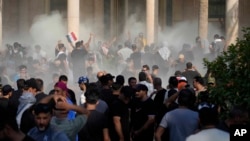 Iraqi security forces fire tear gas on the followers of Shiite cleric Muqtada al-Sadr inside the government Palace, Baghdad, Iraq, Aug. 29, 2022.