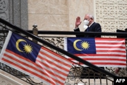 Mantan Perdana Menteri Malaysia Najib Razak melambai saat dia tiba di pengadilan federal di Putrajaya pada 23 Agustus 2022. (Foto: AFP)
