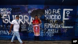 Clemente Rodriguez holds a poster of his missing son Christian, during a march seeking justice for the missing 43 Ayotzinapa students, in Mexico City, Aug. 26, 2022.