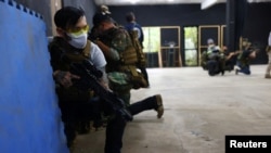 Sebuah SMA di Taiwan telah mendirikan lapangan tembak indoor di kompleksnya, di mana para instruktur militer membantu melatih para siswa menggunakan senapan dan senjata lainnya (Foto: Reuters)