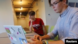 Hlib Burtsev and Oleksii Shebanov, both from Ukraine, check their email in the common area of their dorm ahead of their first year at Brown University in Providence, Rhode Island, U.S., August 16, 2022. (REUTERS/Brian Snyder)