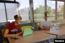 Hlib Burtsev and Oleksii Shebanov, both from Ukraine, check their email in the common area of their dorm ahead of their first year at Brown University in Providence, Rhode Island, U.S., August 16, 2022. (REUTERS/Brian Snyder)