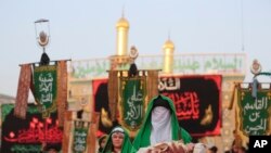 Peringatan Ashura Muslim Syiah yang menandai kesyahidan Husain bin Ali, cucu Nabi Islam Muhammad, dan anggota keluarga dekatnya dalam Pertempuran Karbala, di Karbala, Irak, Senin, 8 Agustus 2022. (AP /Anmar Khalil)