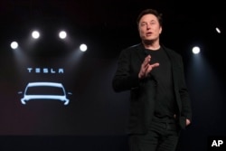 FILE - Tesla CEO Elon Musk speaks before unveiling the Model Y at the company's design studio, in Hawthorne, California, March 14, 2019.