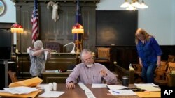 FILE - Esmeralda County Commissioner Ralph Keyes, center, works on a hand recount of votes with others, June 24, 2022, in Goldfield, Nevada. 