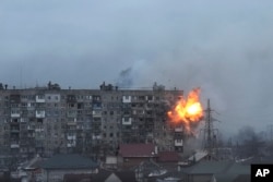 FILE - An apartment building explodes after Russian army tank fire in Mariupol, Ukraine, March 11, 2022.