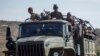 FILE - Ethiopian government soldiers ride in the back of a truck on a road near Agula, north of Mekelle, in the Tigray region of northern Ethiopia on May 8, 2021.