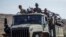 FILE - Ethiopian government soldiers ride in the back of a truck on a road near Agula, north of Mekelle, in the Tigray region of northern Ethiopia on May 8, 2021.