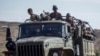 FILE - Ethiopian government soldiers ride in the back of a truck on a road near Agula, north of Mekelle, in the Tigray region of northern Ethiopia, May 8, 2021.