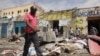 FILE - Residents look at the scene of an al-Qaida-linked al-Shabab group militant attack, in Mogadishu, Somalia, Aug. 21, 2022. 