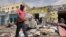 FILE - Residents look at the aftermath of an al-Shabab militant attack in Mogadishu, Aug. 21, 2022. 