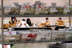 Workers with the Philadelphia City Commissioners office sort election materials for the 2020 General Election in the United States at the city's mail-in ballot sorting and counting center, in Philadelphia, Oct. 26, 2020.