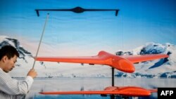 A man works at a booth displaying drones on the eve of the ninth China International Aviation and Aerospace Exhibition in Zhuhai, November 12, 2012.