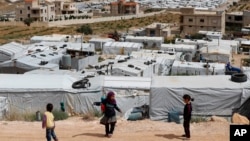 Anak-anak pengungsi Suriah bermain di dekat kamp pengungsi sementara yang dibangun di antara permukiman penduduk dan bangunan-bangunan lainnya di Arsal, perbatasan Suriah-Lebanon timur, 13 JUni 2018. (Foto: dok). 