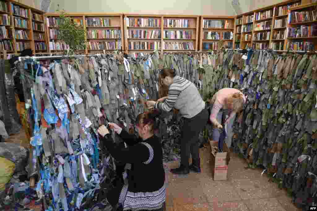 Volunteers make camouflage nets for the Ukrainian military at a library in western city of Lviv, March 1, 2022.