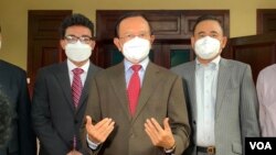 លោក​ កឹម​ សុខា​ (កណ្ដាល) មេដឹកនាំគណបក្សប្រឆាំង​​ផ្តល់​សម្ភាសន៍​ដល់​អ្នក​សារព័ត៌មាន​ នៅ​គេហដ្ឋាន​របស់​លោក​ មុន​ចេញ​ទៅ​ចូល​រួម​សវនាការ​ នា​ថ្ងៃទី​២​ ខែ​មីនា​ ឆ្នាំ​២០២២​។ (កាន់​ វិច្ឆិកា​/វីអូអេ)