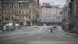A man crosses a deserted boulevard during an air raid alarm, in Kyiv, March 1, 2022.