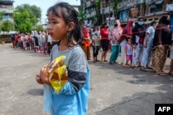 Warga antre membeli minyak goreng murah di Palembang, Sumatra Selatan, menyusul kelangkaan minyak sawit, bahan baku pembuatan minyak goreng, Kamis, 24 Februari 2022. (Foto: Abdul Qodir/AFP)
